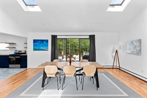 a dining room with furniture a rug and a large window
