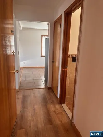 an empty room with wooden floor and a bathroom