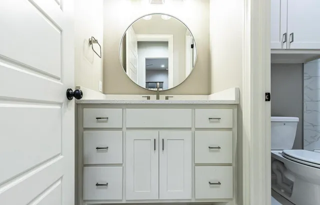 a bathroom with a sink vanity and mirror