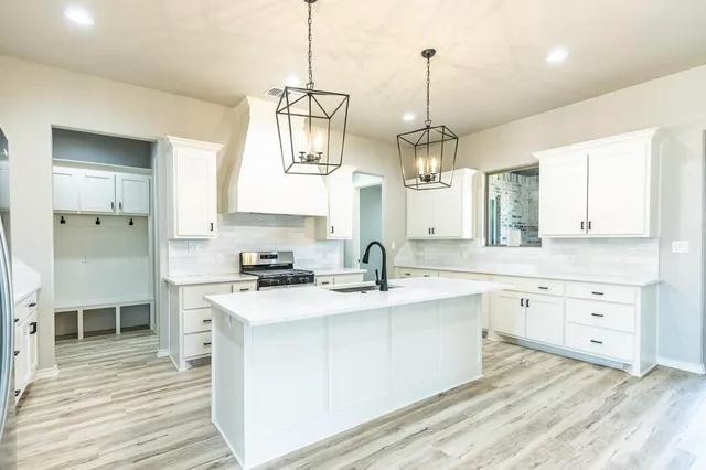 a kitchen with a sink stove and cabinets