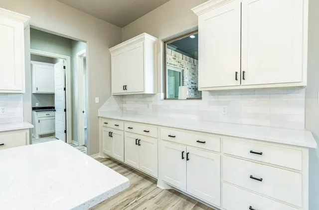 a kitchen with granite countertop white cabinets and sink