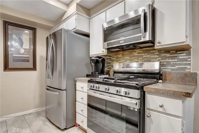 a kitchen with stainless steel appliances granite countertop a stove and a refrigerator