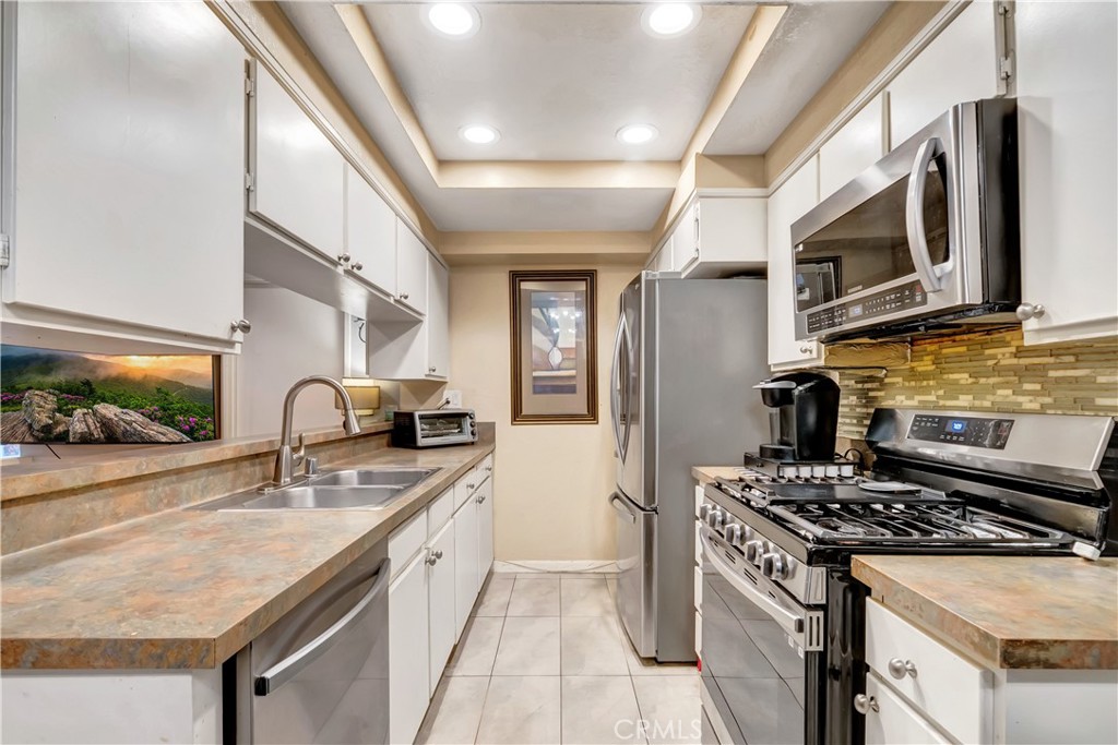 1523 East Windsor Road, Unit 208A Glendale, CA 91205 - Photo 9 of 27 a kitchen with stainless steel appliances granite countertop a stove a sink and a microwave