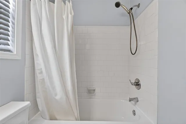 a bathroom with a bath tub with a shower curtain