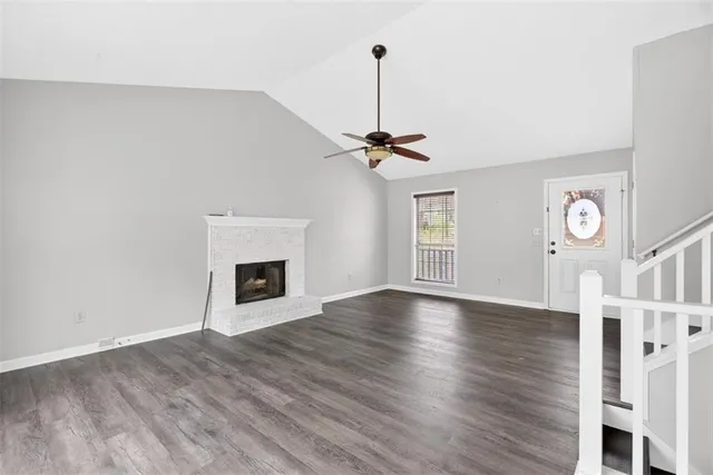 a view of an empty room with a window and fireplace