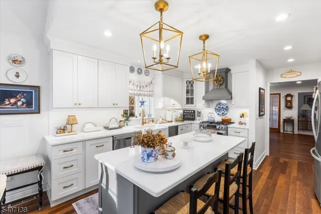 a view of a dining room and livingroom with furniture wooden floor a rug a chandelier