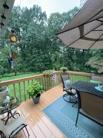a balcony with wooden floor table and chairs
