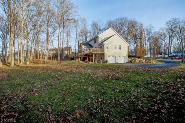 a view of a white house with a big yard and large trees