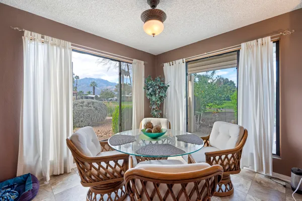 a dining room with furniture a chandelier and wooden floor