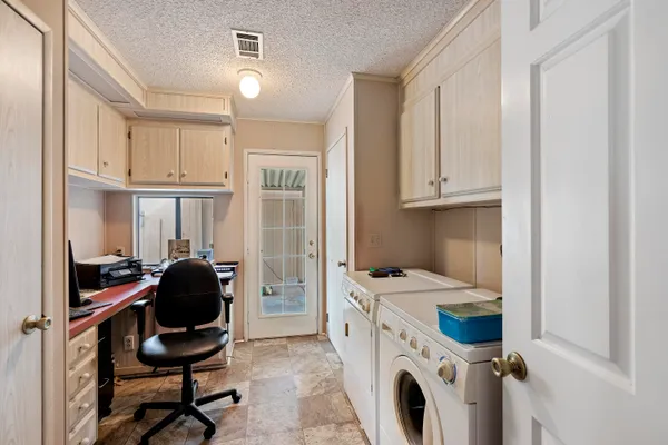 a view of a kitchen with washing machine and racks