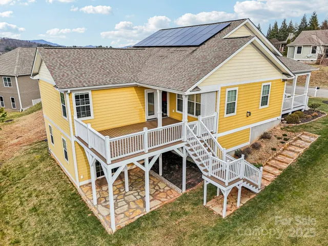 a view of a house with wooden deck and furniture