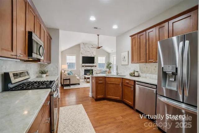 a kitchen with stainless steel appliances granite countertop a refrigerator stove microwave and sink