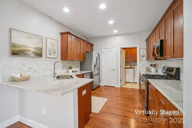 a kitchen with stainless steel appliances granite countertop a sink stove and refrigerator