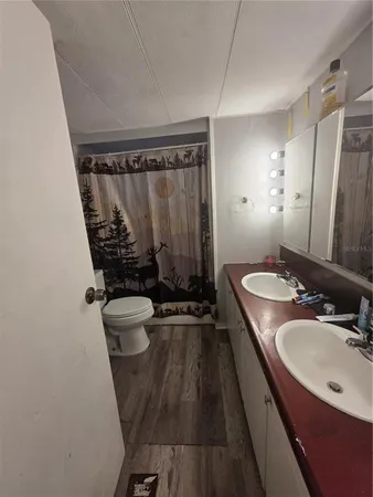 a bathroom with a sink a toilet a mirror and shower