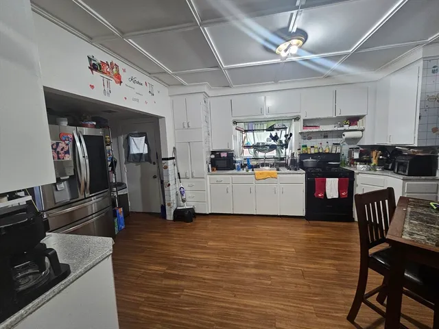 a view of a kitchen with fridge and wooden floor