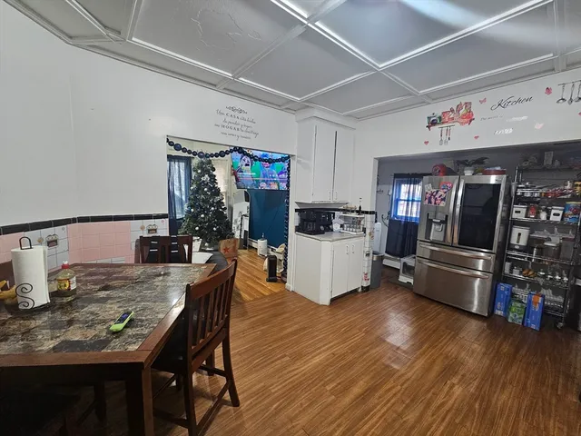 a kitchen with stainless steel appliances kitchen island granite countertop a table chairs and a refrigerator