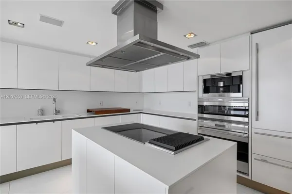 a kitchen that has a sink and a stove top oven