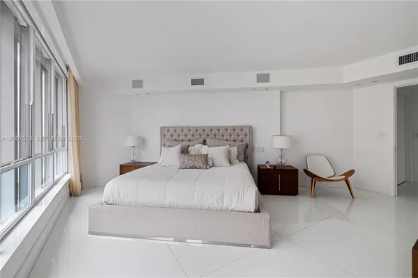 a bedroom with a bed chair and window