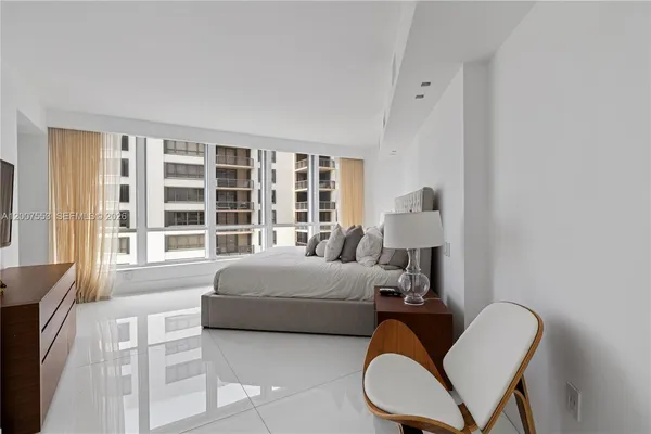 a bedroom with a bed chair and window