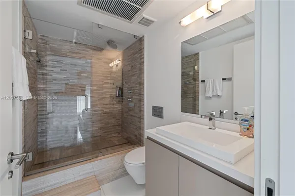 a bathroom with a sink a toilet and shower