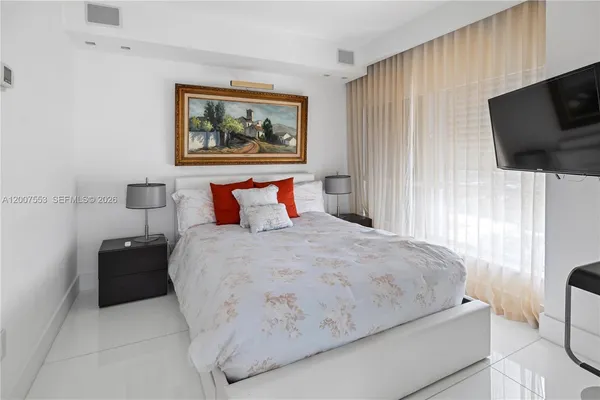 a bedroom with a bed and a flat screen tv