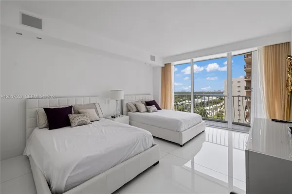 a bedroom with two beds and a large window
