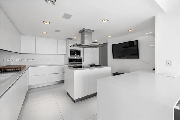 a kitchen with stainless steel appliances a stove a microwave and white cabinets