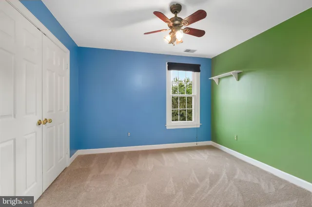 an empty room with a window and a fan