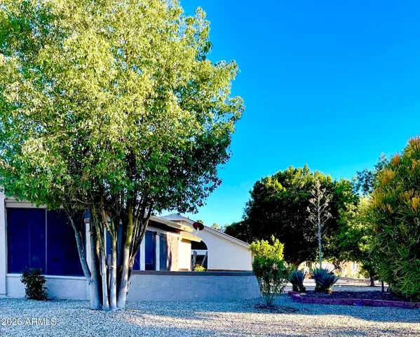 a view of a house with a tree and a yard