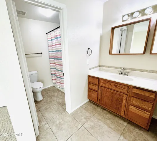 a spacious bathroom with a sink a toilet and a mirror