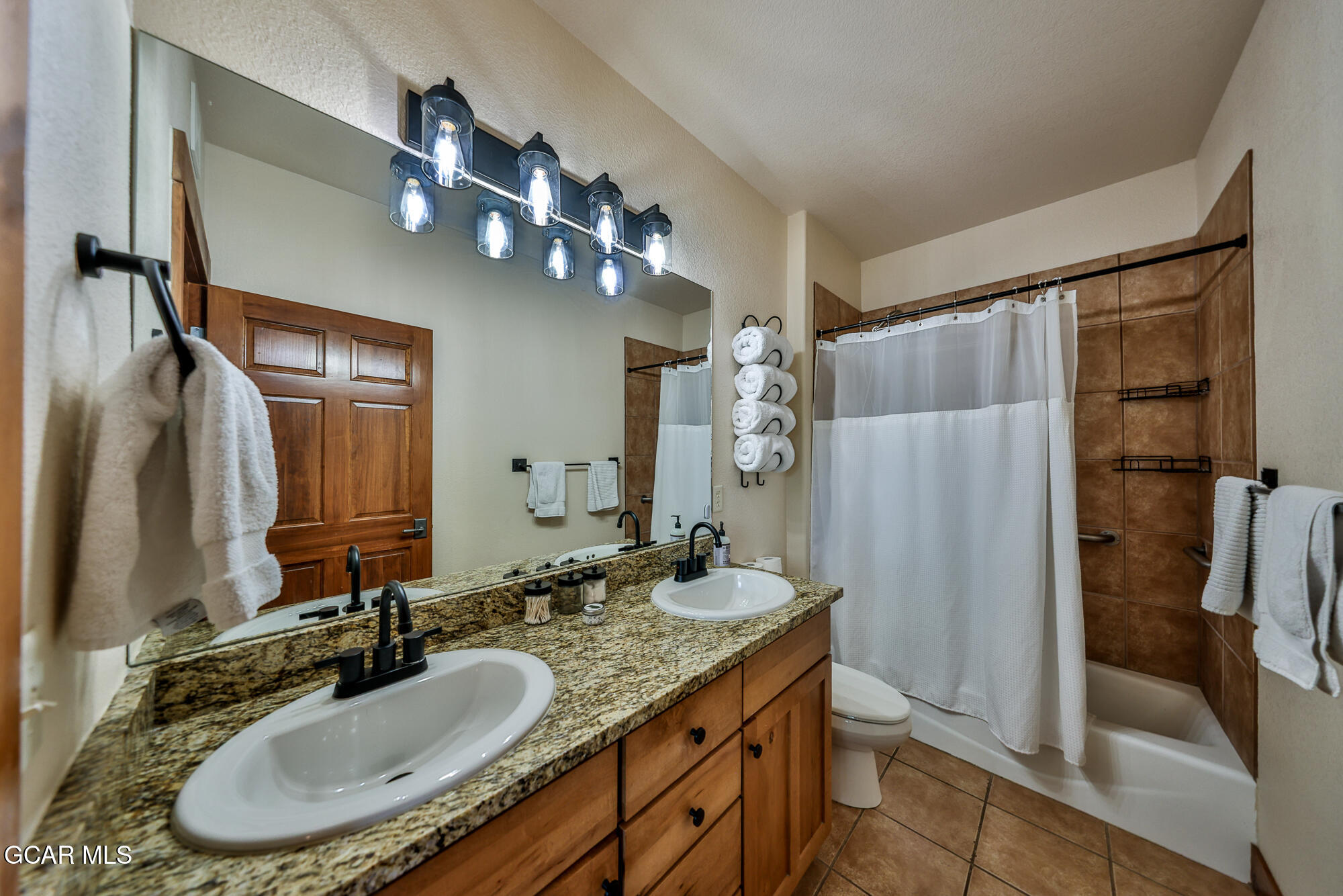 5202 Northstar, Unit 5202 Granby, CO 80446 - Photo 21 of 42 a bathroom with a granite countertop sink a mirror and shower