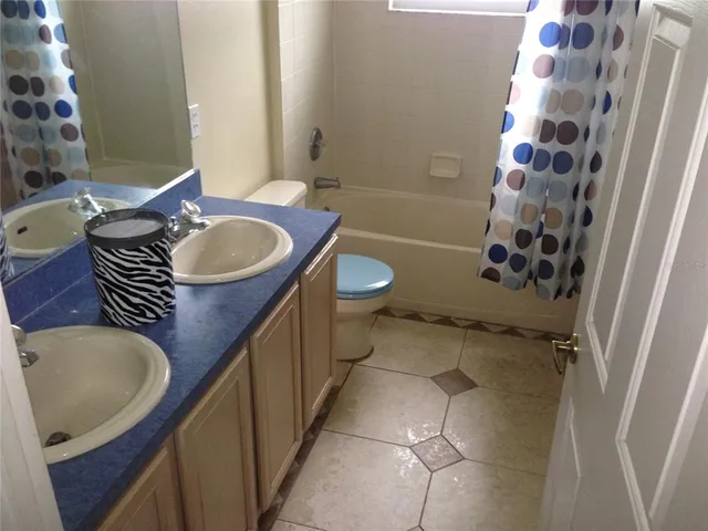 a bathroom with a granite countertop sink toilet a mirror and shower