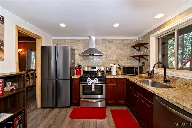a kitchen with stainless steel appliances granite countertop a refrigerator and a sink