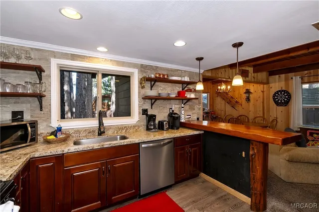 a kitchen with granite countertop a sink stove and cabinets