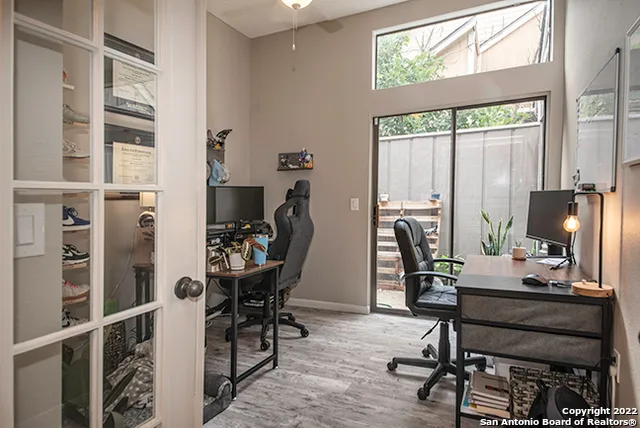 a view of a workspace with furniture and a window