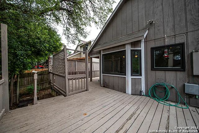 a backyard of a house with wooden floor and fence