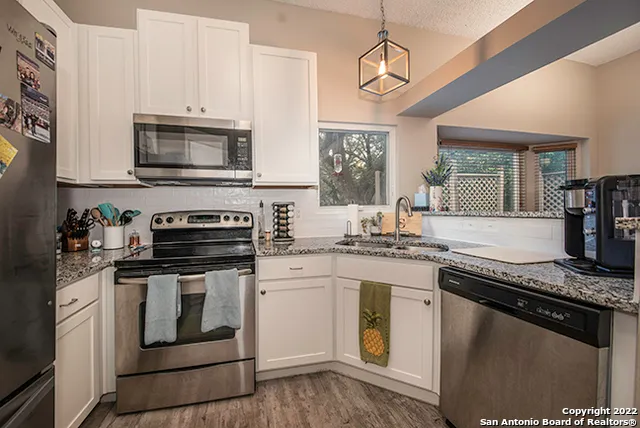 a kitchen with stainless steel appliances granite countertop a stove and a microwave