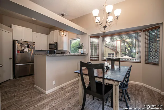 a kitchen with stainless steel appliances granite countertop a kitchen island hardwood floor and a view of living room