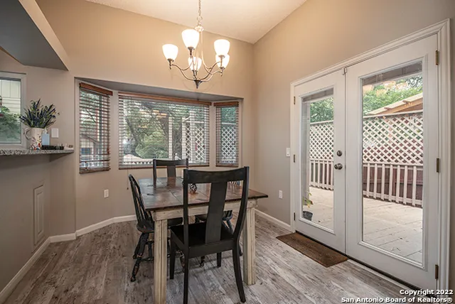a view of a dining room with furniture a chandelier and wooden floor