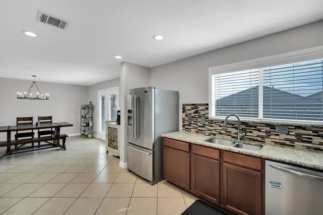 a kitchen with stainless steel appliances kitchen island granite countertop a refrigerator and a stove top oven