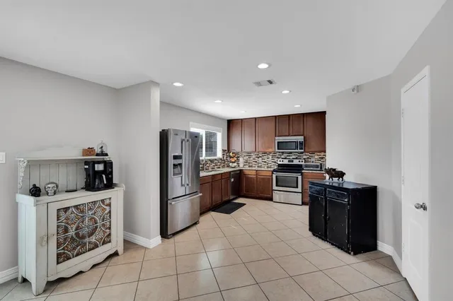 a kitchen with stainless steel appliances kitchen island granite countertop a refrigerator sink and cabinets