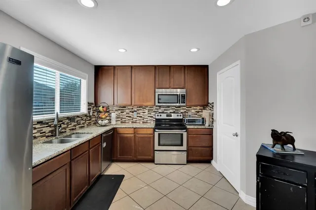 a kitchen with stainless steel appliances granite countertop a stove and a sink