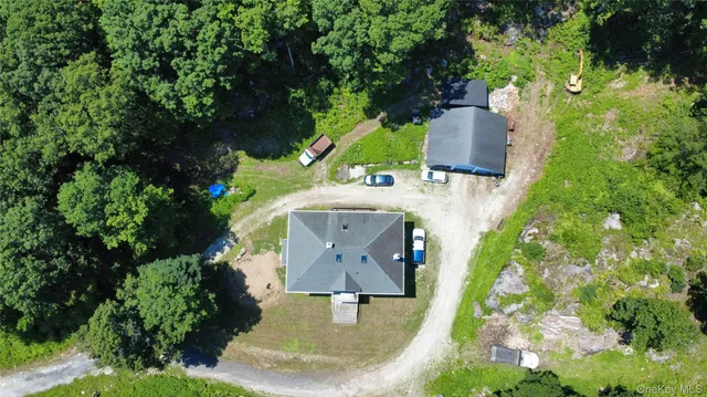 an aerial view of a house with a yard and trees all around