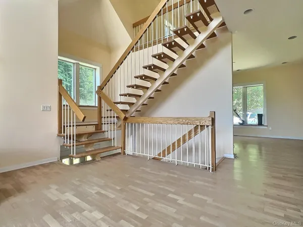 a view of entryway and hall with wooden floor
