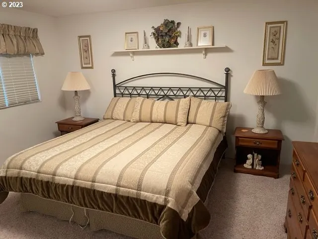 a bedroom with a bed and a lamp on table