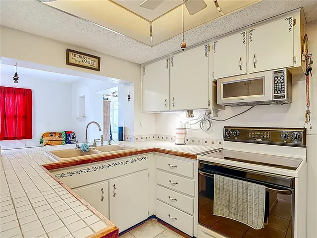 a kitchen with stainless steel appliances granite countertop white cabinets and window
