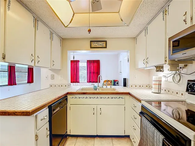 a kitchen with a sink a stove and cabinets