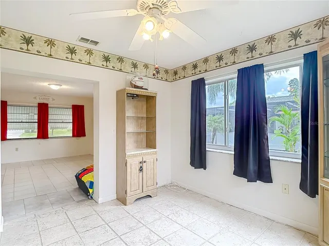 an empty room with windows and fan