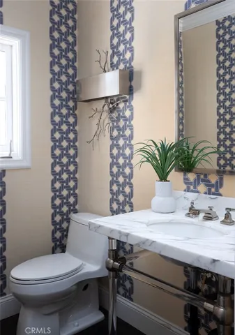 a open kitchen with stainless steel appliances a sink dishwasher a stove a dining table and chairs with wooden floor