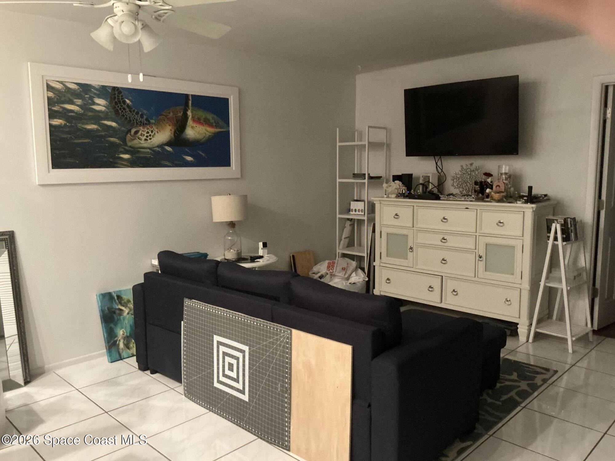 1470 Sheafe Avenue Northeast, Unit 106 Palm Bay, FL 32905 - Photo 6 of 14 a living room with furniture and flat screen tv